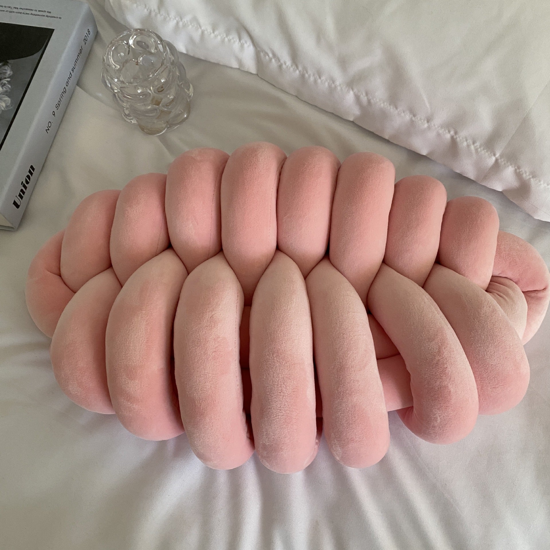 pink knotte caterpillar in a white bed