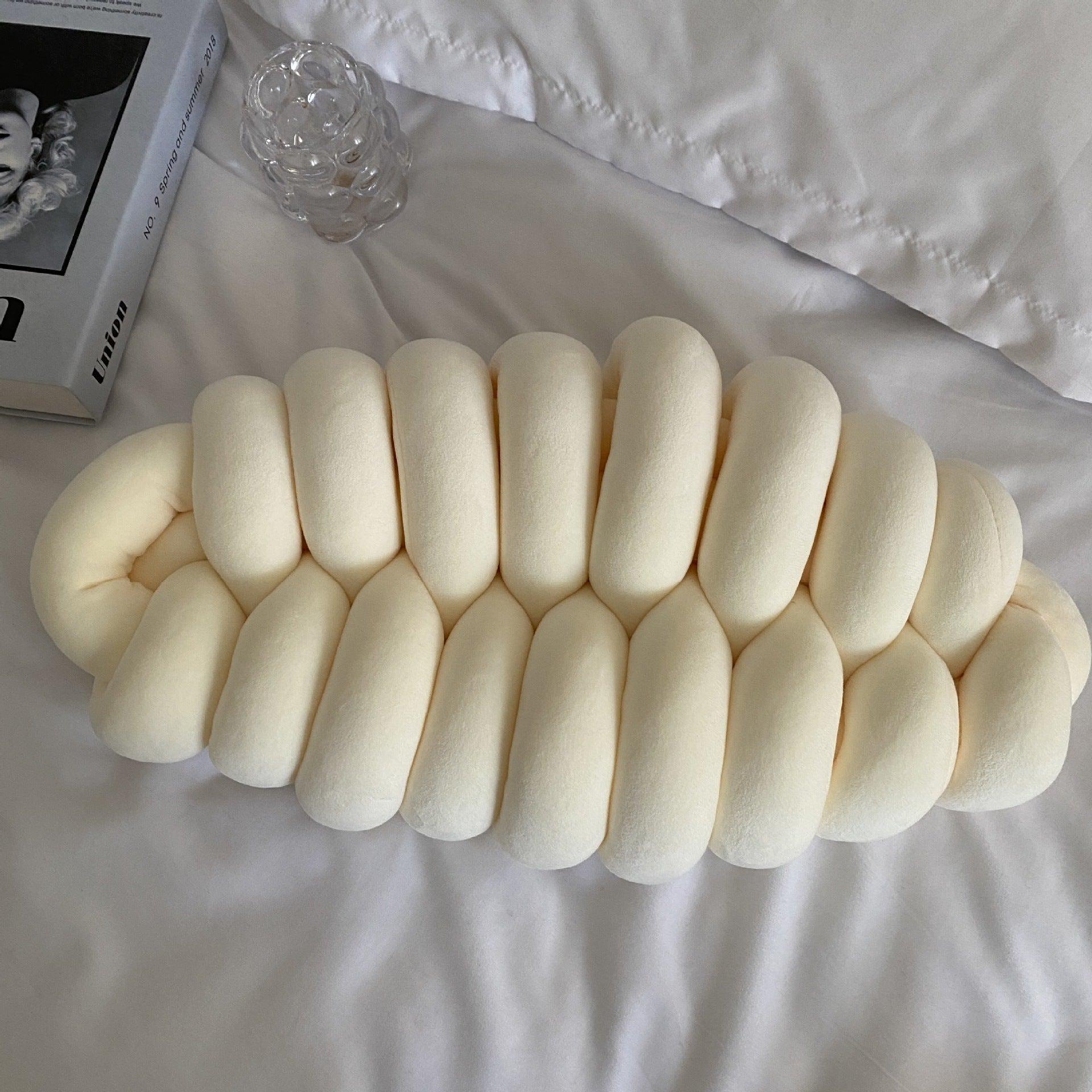 white knotte caterpillar in a white bed