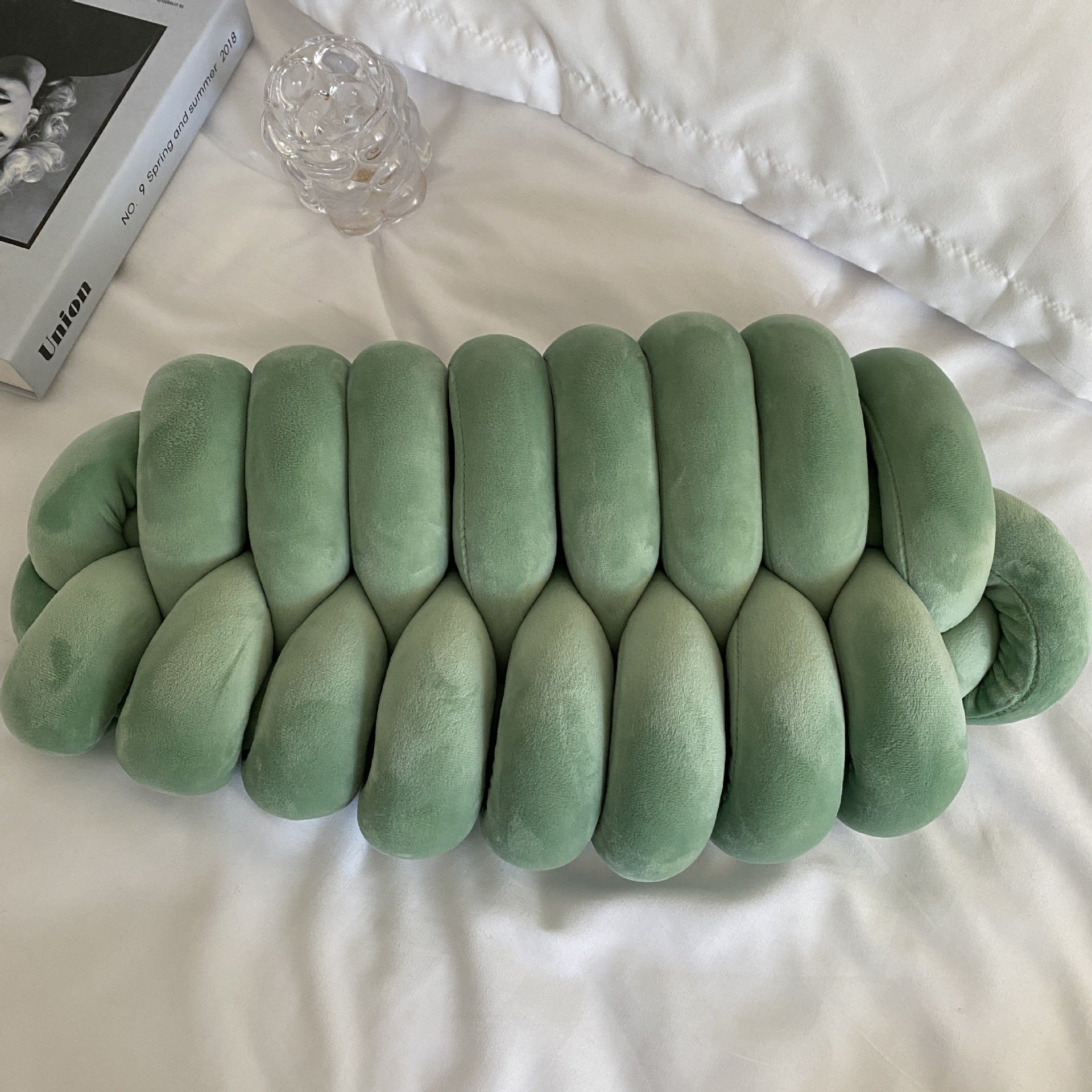 green knotte caterpillar in a white bed