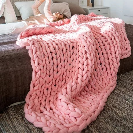 pink knotte blanket in a brown bed