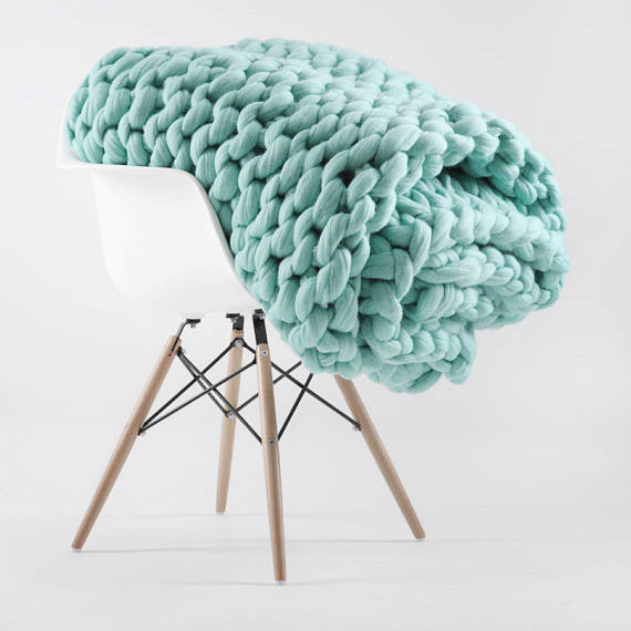 teal knotte blanket in a white chair